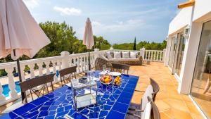 圣安东尼奥Can Paradís的一个带蓝色桌椅和遮阳伞的庭院