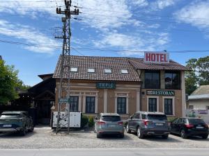 TemerinTEPIĆ Garni Hotel的门前有车辆停放的酒店