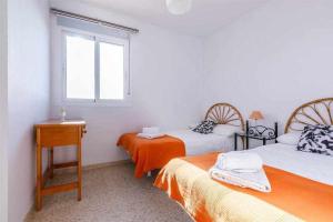 托雷德尔马尔A&N Río de la Plata的一间卧室设有两张床和窗户。
