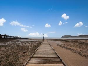 兰迪德诺The Llandudno Hotel的海滩上的木路,远处设有灯塔