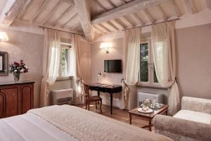 科尔托纳Villa di Piazzano - Small Luxury Hotels of the World的一间卧室配有一张床和一张书桌