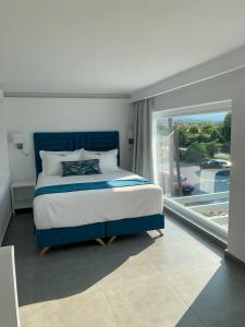 伊里斯斯Ocean Blue Suites的一间卧室设有一张床和一个大窗户