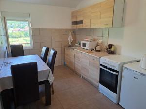 采蒂涅Apartments Mirković的一间带桌子和微波炉的小厨房