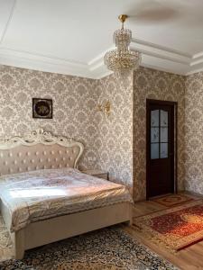 奥什Тумар的一间卧室配有一张床和一个吊灯
