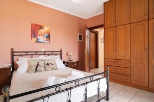梅加尼西岛Lakis Apartment的一间卧室配有一张大床和一个木制橱柜