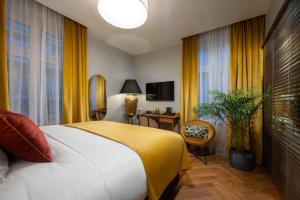 华沙Sava Boutique Hotel的酒店客房设有一张床、一张书桌和窗户。