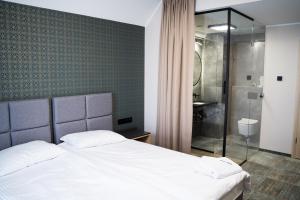 马尔堡BULVAR的卧室配有白色的床和淋浴