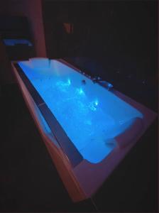 阿让Le Foyer d'Or - Hypercentre & Confort的客房内的蓝光热水浴池