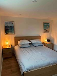 比亚里茨Logement avec piscine privée chauffée的一间卧室配有一张带两盏灯的床。