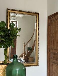 罗什福尔Maison Comtale的绿色花瓶坐在镜子前的桌子上