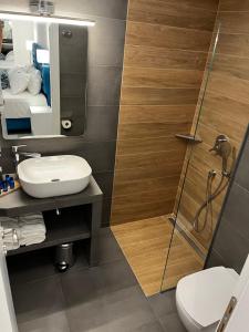 伊里斯斯Ocean Blue Suites的带淋浴、卫生间和盥洗盆的浴室