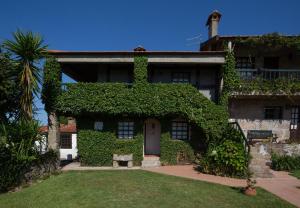 雷森迪Quinta da Graca- Complexo Turistico的常春藤覆盖的楼房,有门和树