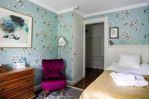 Grythyttan吉日塔昂斯盖特吉瓦瑞吉德酒店的一间卧室配有一张床和一张紫色椅子