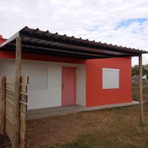 科洛尼亚-德尔萨克拉门托Maria Hospedaje Diario的红色和白色的小房子,有红色的门