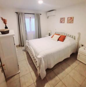 萨尔塔Casa en Salta的卧室配有一张带白色床单和橙色枕头的大床。