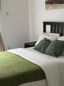 阿克拉‪Luxury One Bed Apt w/Balcony in Cantonment的一张带绿色和白色毯子及枕头的床