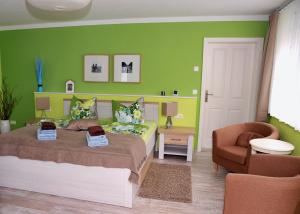 吕本瑙Ferienhaus im Gurkengässchen的一间卧室设有绿色的墙壁、一张床和椅子