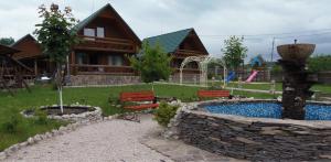 波利亚纳卡琳娜游客大厦酒店的小木屋设有游泳池、长椅和房屋