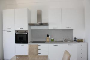 切列梅萨皮卡La Mia Villa的白色的厨房配有白色橱柜和水槽