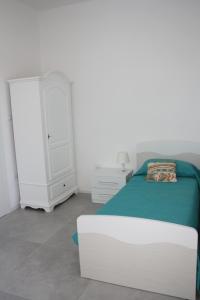 切列梅萨皮卡La Mia Villa的一间白色卧室,配有一张床和一个梳妆台