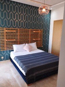 西迪拉哈尔Casabay appartement pied dans l'eau 87 m2的一间卧室配有一张带蓝色毯子的大床