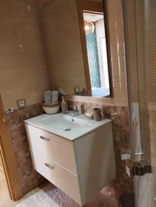 西迪拉哈尔Casabay appartement pied dans l'eau 87 m2的浴室设有白色水槽和镜子