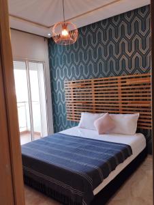 西迪拉哈尔Casabay appartement pied dans l'eau 87 m2的一间卧室配有一张带蓝色毯子的大床