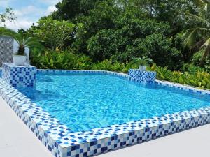 珍南海滩兰卡威卡帕泰邦酒店的周围拥有蓝色和白色瓷砖的游泳池