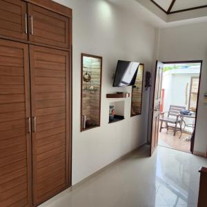 卡马拉海滩Bungalows Musch Kamala Phuket的一间设有木制衣柜和墙上电视的房间