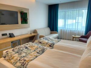 布勒伊拉Alma Health & Spa Retreat的配有一张床和一台平面电视的酒店客房