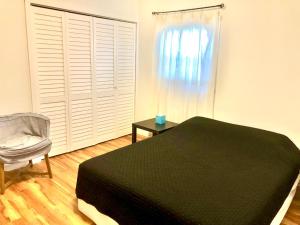 明尼阿波利斯Homey 2 bedroom Apartment, Minutes from Everything!的卧室配有床、椅子和窗户。