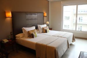 维戈维戈城市酒店的一间卧室设有两张床和大窗户