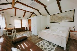 伊钦Villa Libosad的卧室配有一张白色的大床和一张桌子