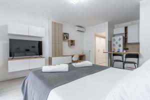 米兰Santa Giulia Suite的一间白色卧室,配有一张大床和一个厨房