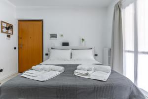 米兰Santa Giulia Suite的白色卧室,配有带毛巾的床