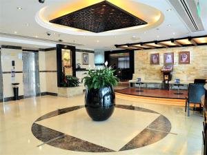 迪拜Signature Inn Hotel - Free Parking的坐在大堂地板上的黑色大花瓶
