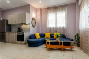 普雷韦扎Aktia Apartment, Preveza的客厅配有蓝色的沙发和黄色的枕头。