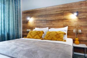 伊里斯斯Okean Apartments的一间卧室配有一张大床和木制床头板