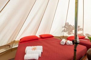 莫塔卡玛斯特拉Gole Alcantara mini Campeggio privato的帐篷内的一张床位,配有毛巾