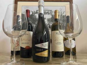 Montalto delle MarcheLa Dispensa的桌子上放着一组葡萄酒瓶和玻璃杯