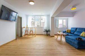 巴尔巴特Edificio Manuel de Falla Apartamentos的一间带蓝色沙发的客厅和一间厨房