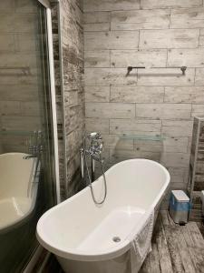 伊万诺-弗兰科夫斯克芬特什精品酒店的浴室配有白色浴缸及水槽
