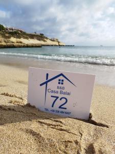 托雷斯港b&b Casa Balai 72 a 100 mt dal mare的海滩上的沙子上的一个标志
