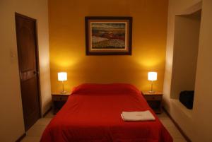 阿雷基帕阿雷基帕旅馆的卧室配有红色的床,两边都配有两盏灯