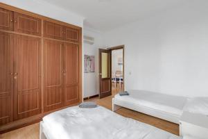 马德里AVE Apartamento Madrid Centro Atocha的一间卧室设有两张床和木制橱柜。
