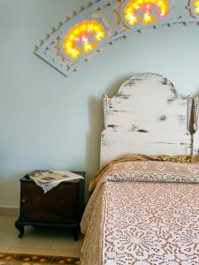 马萨夫拉Novecento Room and Breakfast Puglia的卧室配有一张床,墙上设有灯。
