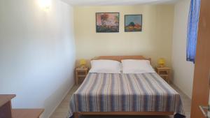 康斯基TAKOMA的一间卧室配有一张带两个枕头的床