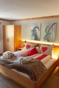 圣安特尼恩Hotel Madrisajoch的一间卧室配有一张带红色和白色枕头的大床