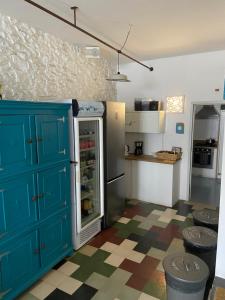 阿尔热祖尔Amazigh Hostel & Suites的厨房配有蓝色橱柜和冰箱