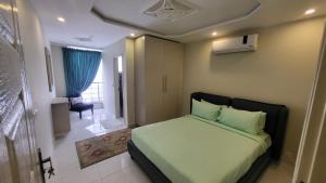拉合尔C Suites的一间卧室配有一张带绿色床单的床和一把椅子